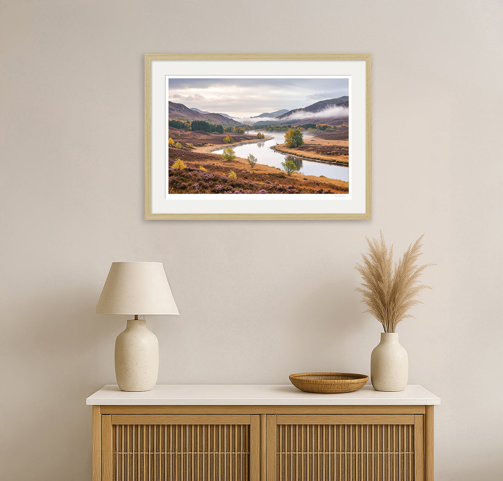 Framed artwork of autumn moorland and river scene with distant deer – black wood frame in home setting