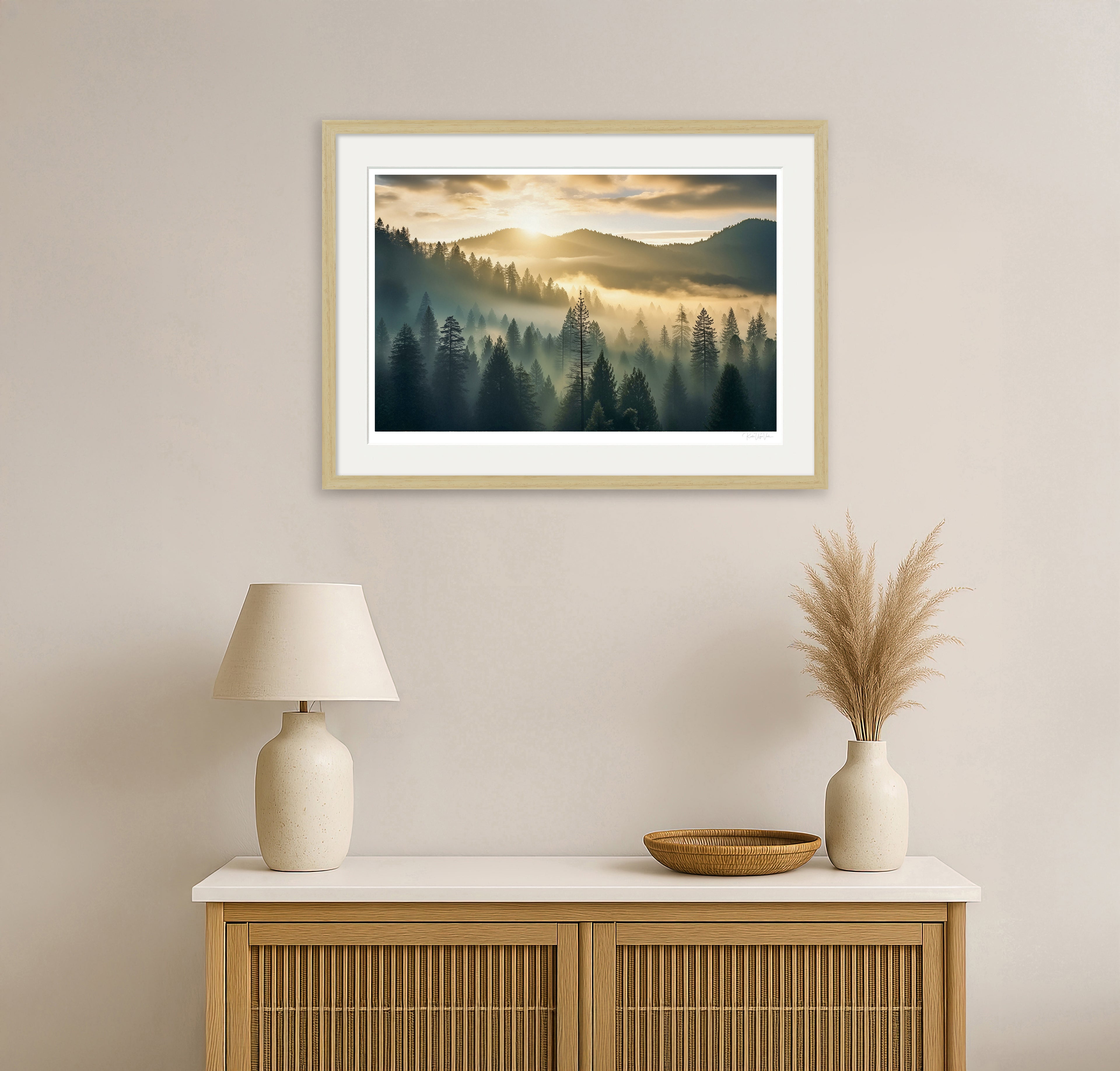 Framed misty forest wall art in natural wood shown above sideboard – golden hour landscape in living room setting