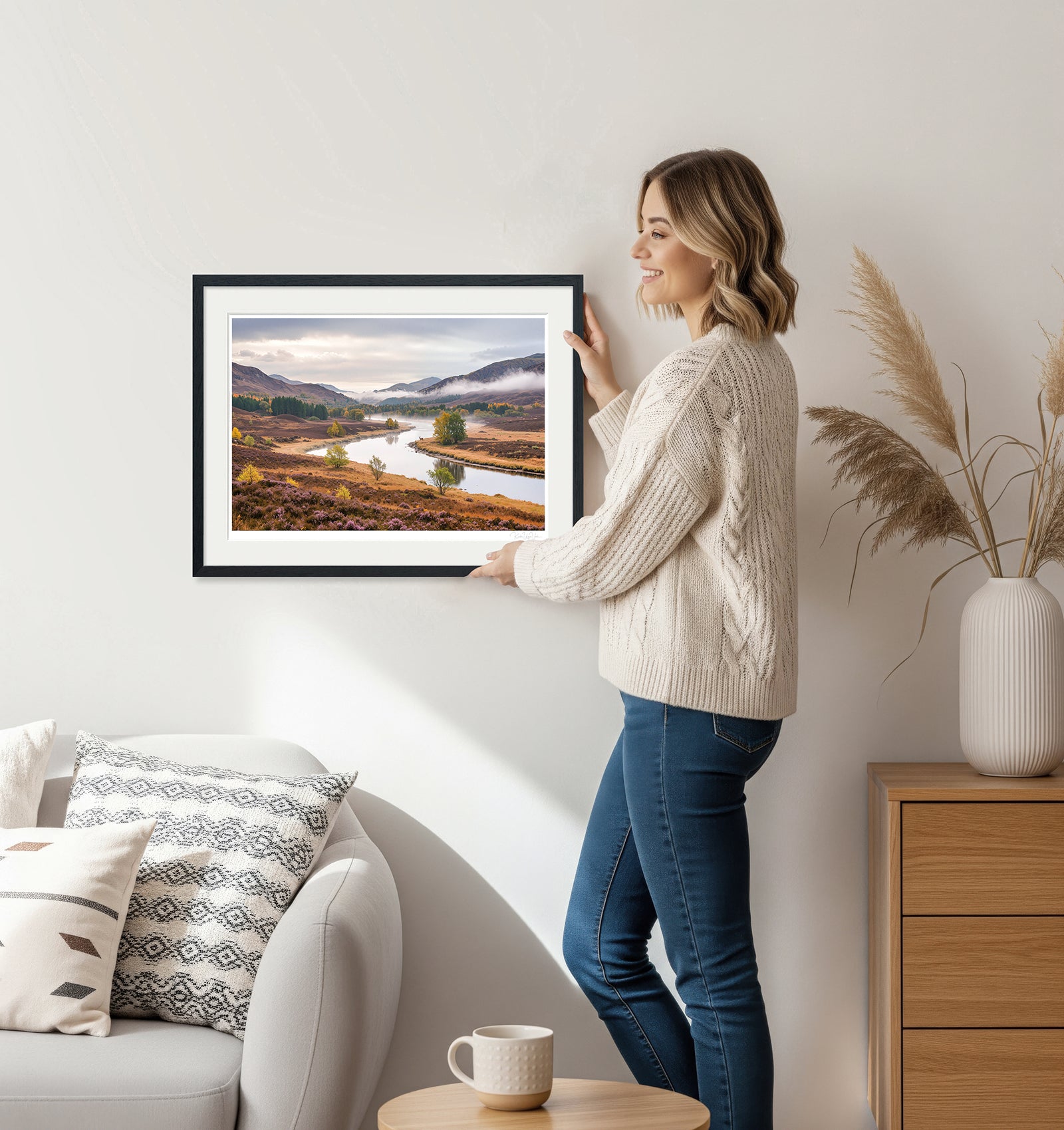 Woman holding framed deer and river autumn landscape print – perfect for calm and elegant wall decor