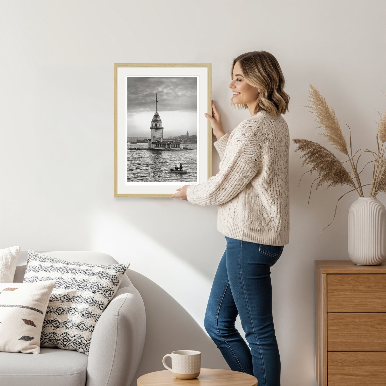 Woman placing natural wood-framed Istanbul wall art on the wall