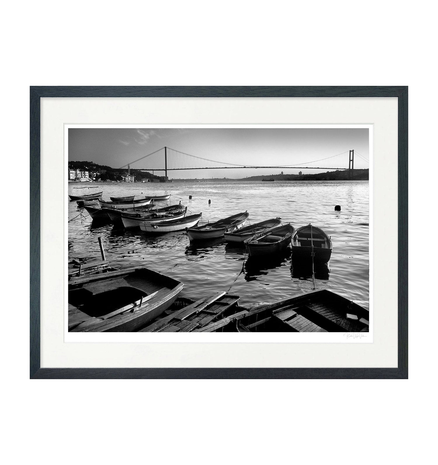 Black and white fine art print of fishing boats on the Bosphorus with Istanbul's bridge in the background – limited edition museum-quality wall art in a black wooden frame.