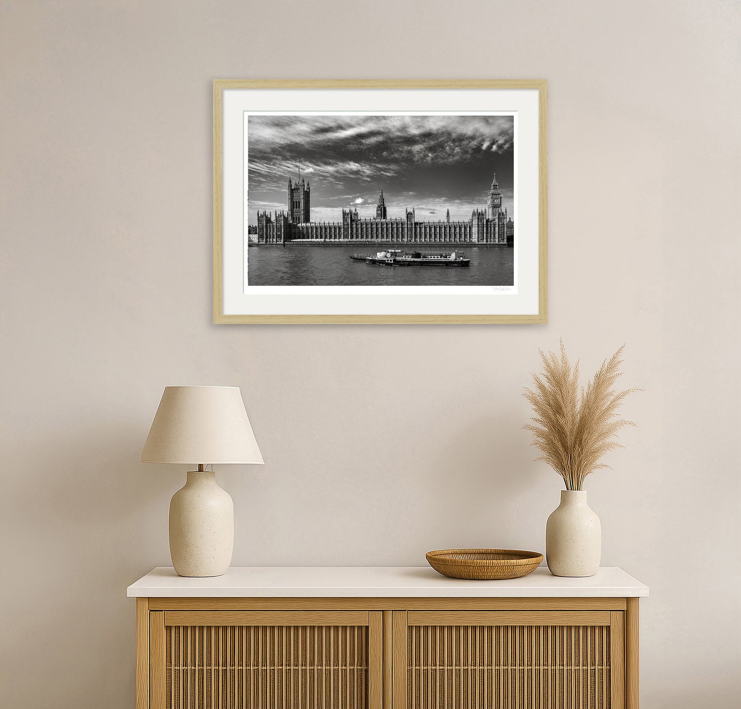 Black and white framed London cityscape print above natural wood console in minimalist home interior