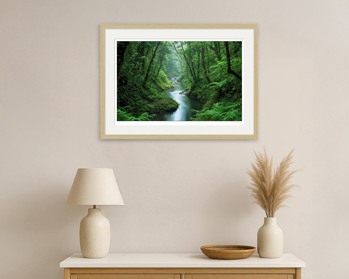 Framed artwork of autumn moorland and river scene with distant deer – black wood frame in home setting