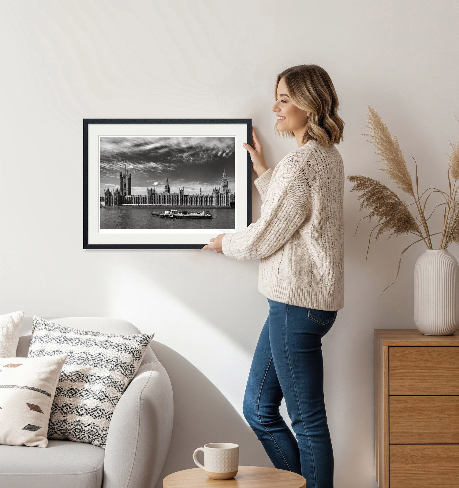 Woman decorating living room with black and white London wall art in elegant setting