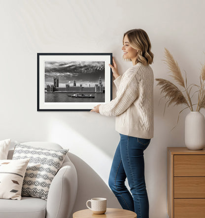 Woman decorating living room with black and white London wall art in elegant setting