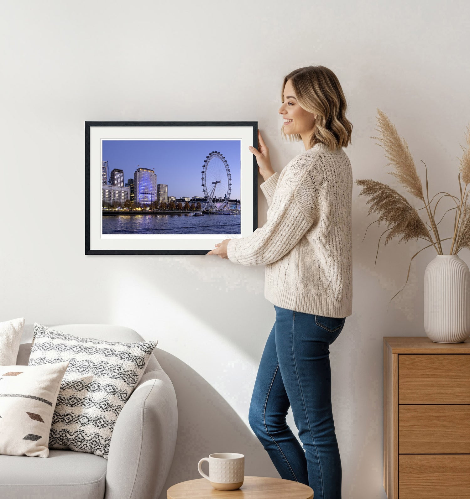 Woman holding framed London Eye wall art with black frame in bright home interior, modern decor
