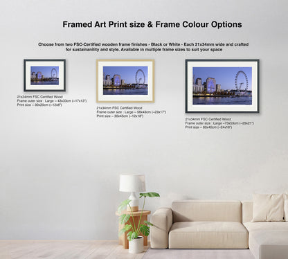Three framed size options of London Eye sunset wall art in black and natural wood frames shown in living room setting