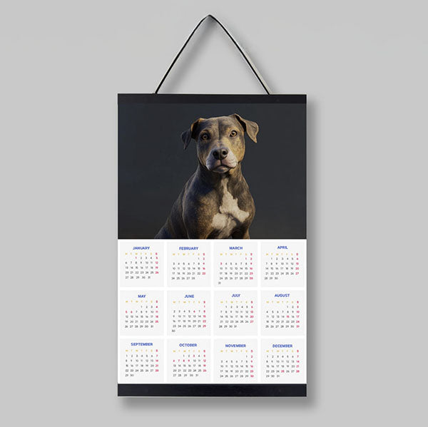 Dog calendar hanging on a wall featuring a detailed photo of a pit bull and a monthly layout.