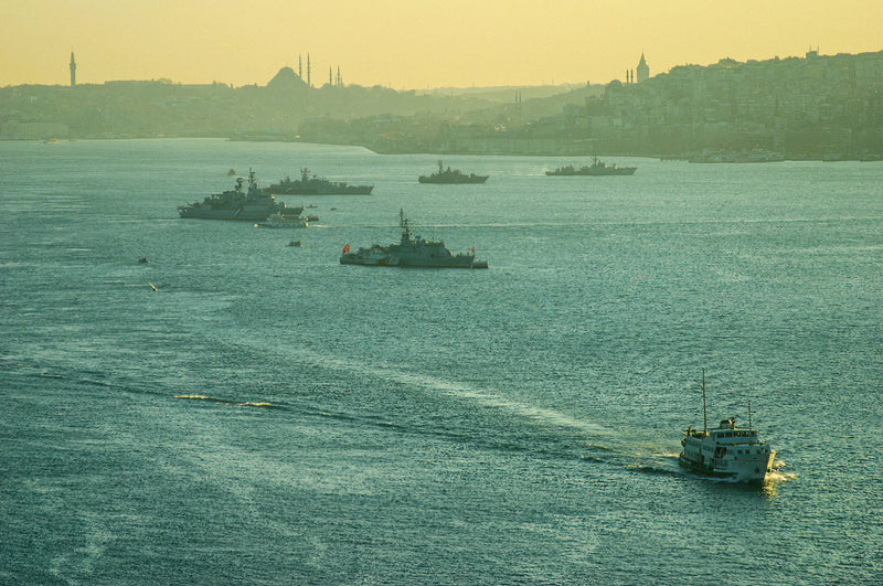 A lone vessel crossing a hazy Bosphorus with Istanbul's misty skyline of minarets and rooftops dissolving in the distance, fine art photography print

